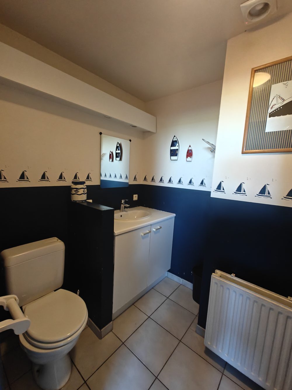 Avant travaux : salle de bain décorée sur le thème marin, WC et meuble d’origine