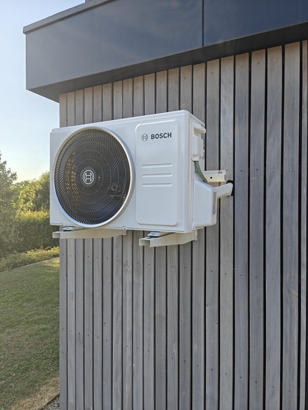 Unité extérieure de climatisation fixée sur un bardage en bois