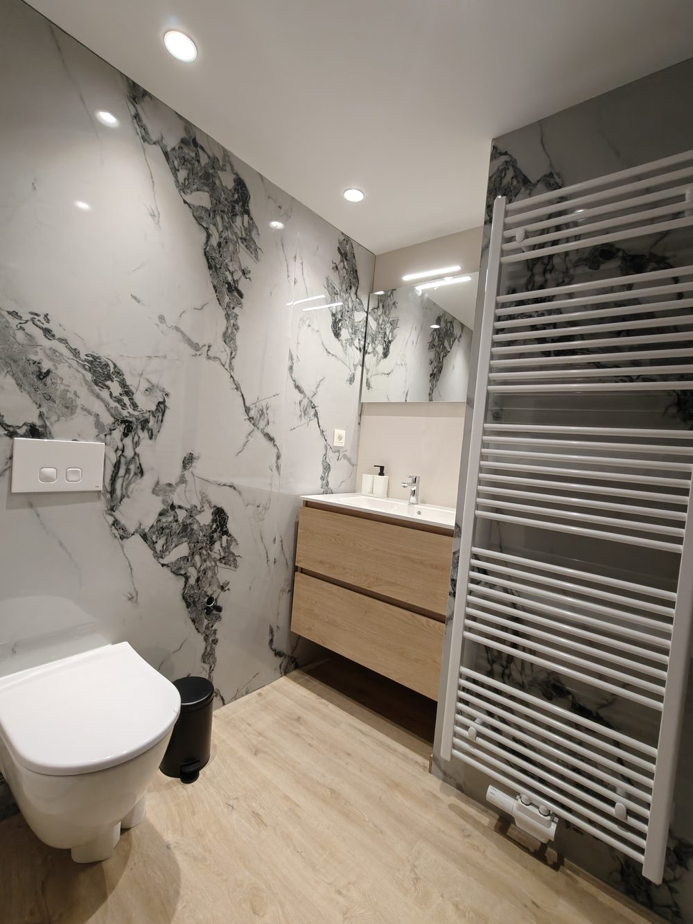 Après travaux : WC suspendu, meuble vasque et parois en marbre blanc veiné